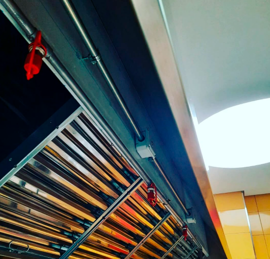 Tubería y boquillas orientadas a filtros, plenum y zona de cocción.